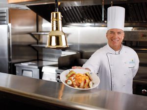 Chef holding out plate of food